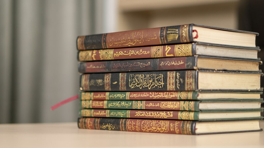 Stack of old hardcover books on a wooden table