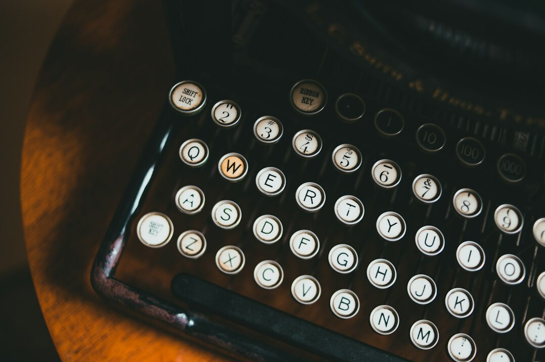 Close-up of vintage typewriter keys on a wooden desk