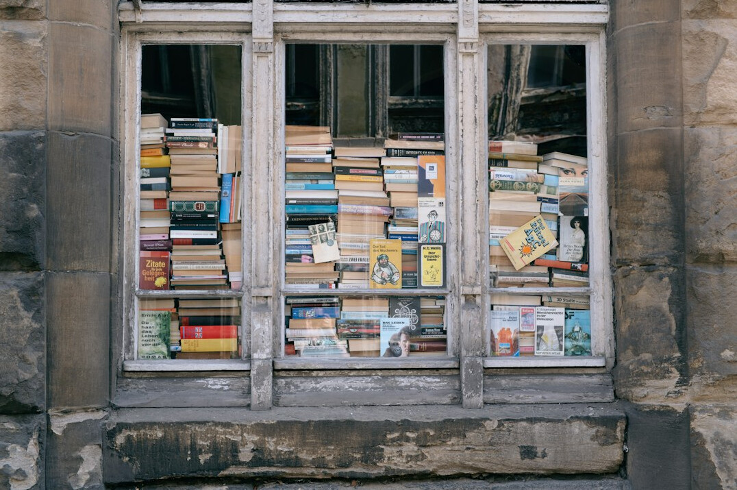 Tall wooden bookshelves filled with old books in a quiet library archive