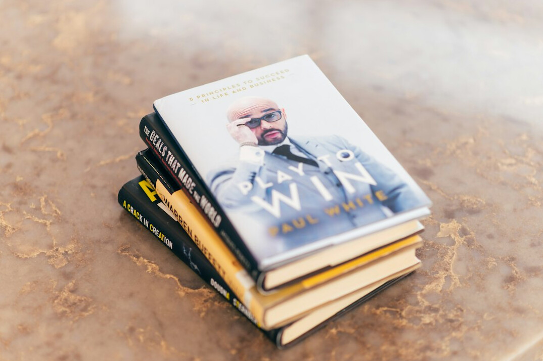 Collection of detective fiction novels stacked on a table