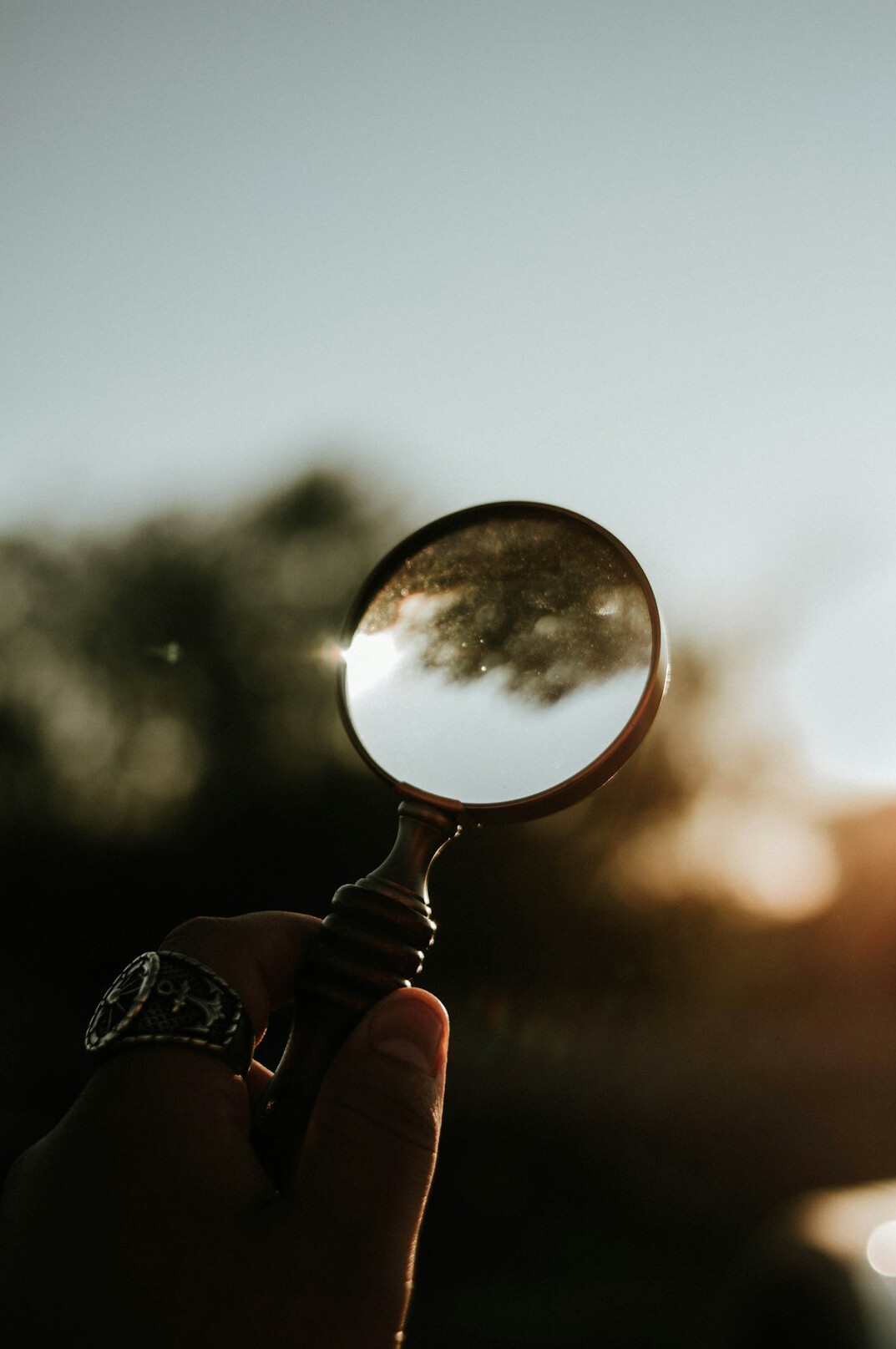 Magnifying glass resting over printed documents on a desk